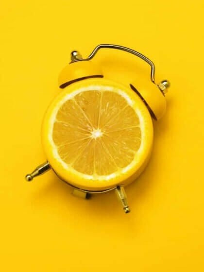 Vintage alarm clock with a lemon slice, a creative metaphor for the power of Vitamin C in breast care routines by Sahra.Nko